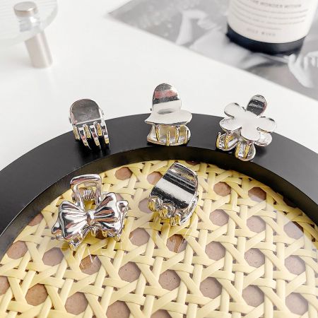 An assortment of stylish silver mini hair claw clips in various designs.