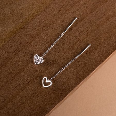 Detailed view of the hollow heart and solid zirconia heart earring designs.