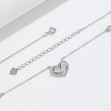 A pair of heart-themed sterling silver jewelry pieces, showcasing the necklace and a matching item.