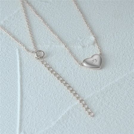 The silver heart necklace shown with its extender chain and clasp for adjustable length.