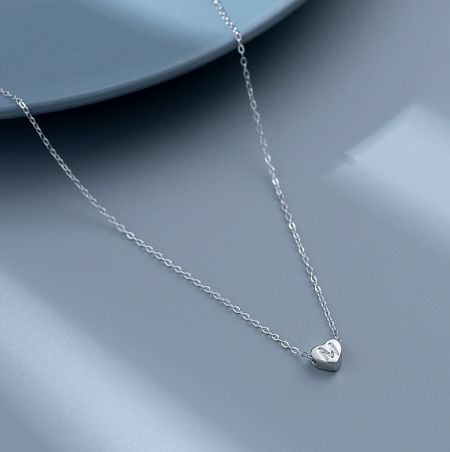 Styled product shot of the elegant 925 sterling silver heart pendant necklace, worn to display its length and appearance.