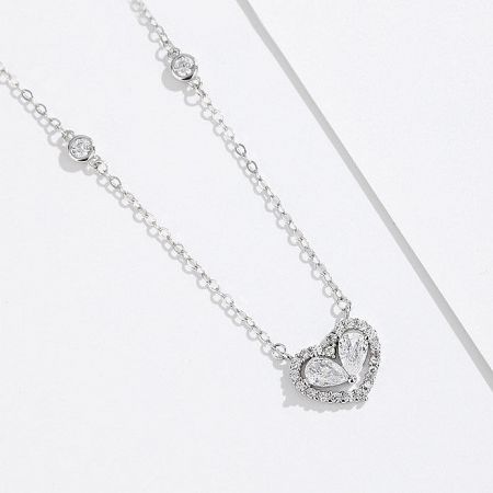 Detailed view of the sterling silver heart necklace with clear gemstones.