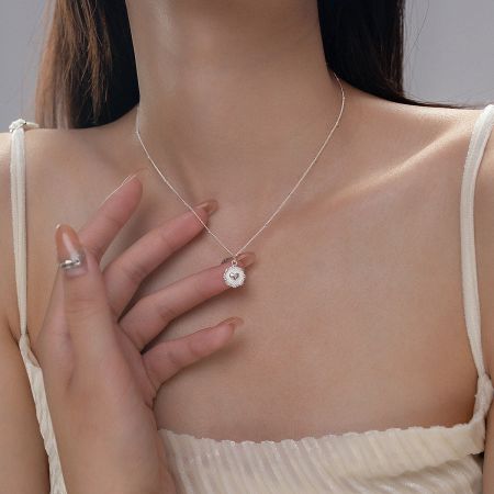 The sterling silver heart pendant necklace worn by a model to show its length and scale.
