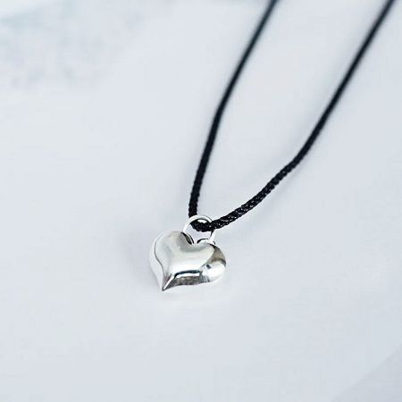 Another angle of the silver heart-shaped pendant and cord.