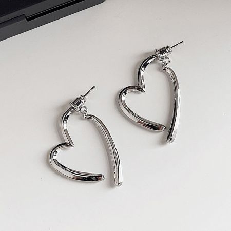 Detailed view of the silver heart stud earrings with 925 silver needle posts.