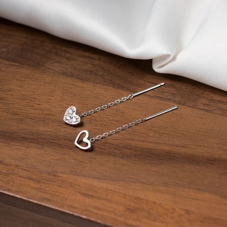 Two styles of sterling silver heart earrings, one hollow and one solid with zirconia, shown side-by-side.