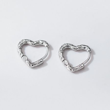Close-up detail of the textured surface on the 925 silver heart-shaped hoop earrings.