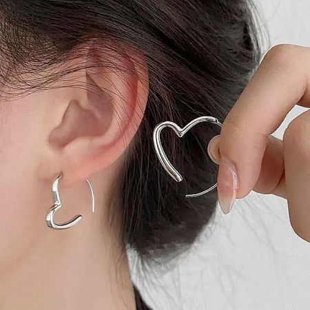 A model showcasing the versatility of the silver heart earrings.