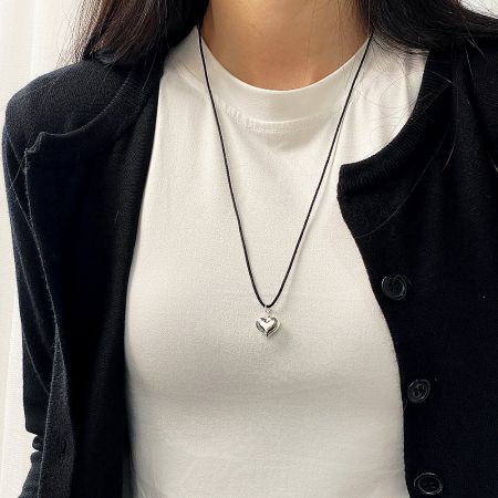 Close-up of the silver heart-shaped pendant necklace.