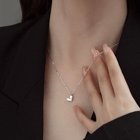 Model wearing the elegant silver heart-shaped pendant necklace.