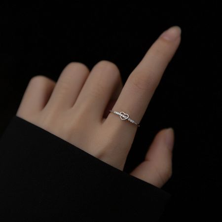 A model wearing the simple and elegant silver heart-shaped adjustable ring on her finger.