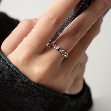 Close-up of the silver heart-shaped zircon ring worn on a finger.