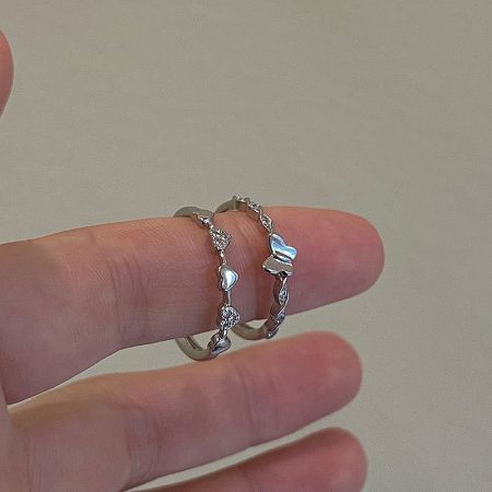 Two sterling silver heart-themed rings from the 5-piece set, a perfect symbol of love and friendship.