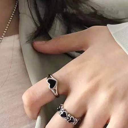 Two silver-plated rings with black enamel hearts from the five-piece set.