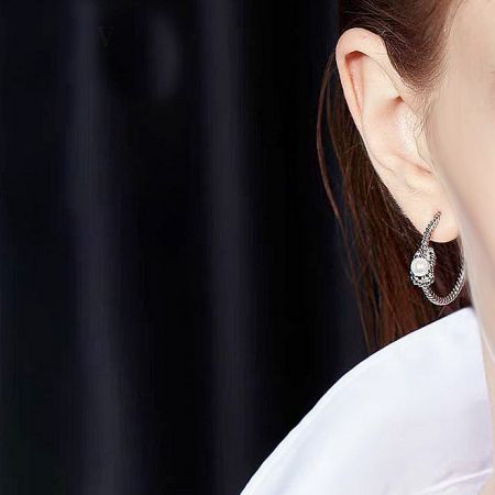 Close-up view of the C-shaped stud earring showing the intricate knot rope detail.