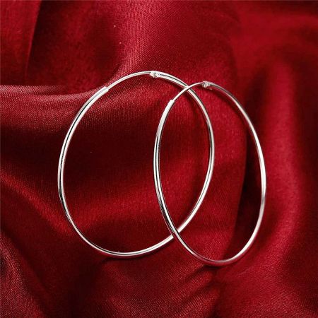 A pair of large 50mm silver hoop earrings with a minimalist design.