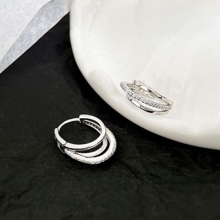 Two pairs of sterling silver hoop earrings displayed, highlighting their brilliant finish and design variations.