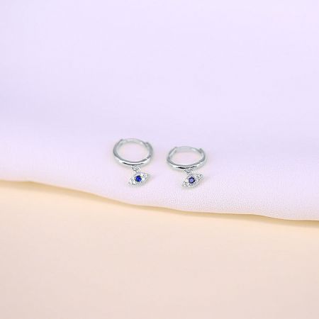 A pair of sterling silver hoop earrings showcasing the blue and clear gemstone evil eye charms.