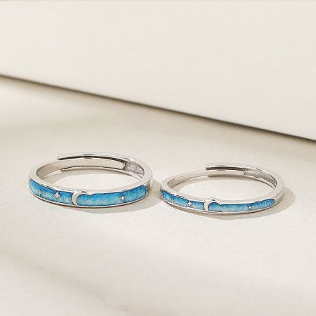 Detailed view of the star and moon enamel design on the sterling silver couple rings.