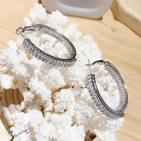 Detailed shot of the silver hoop earrings, focusing on the clarity and cut of the clear gemstones.