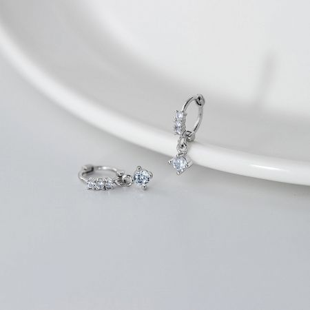 Detailed view of a pair of silver hoop earrings from the set, featuring brilliant-cut cubic zirconia stones.