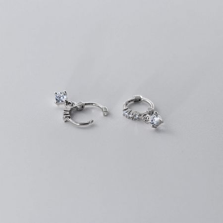 A pair of sterling silver earrings with clear gemstones, showcasing their elegant design.