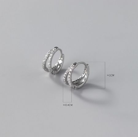 Detailed view of a silver hoop earring with sparkling cubic zirconia accents and measurement guides.