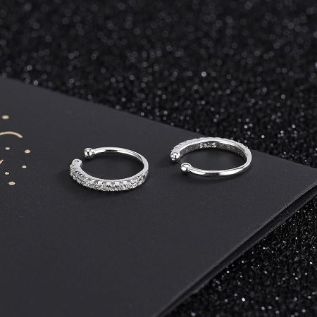 A pair of sterling silver CZ encrusted ear cuffs shown in detail.