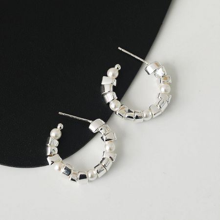 Detailed view of the silver hoop earring showcasing the pearl and cubic bead arrangement.