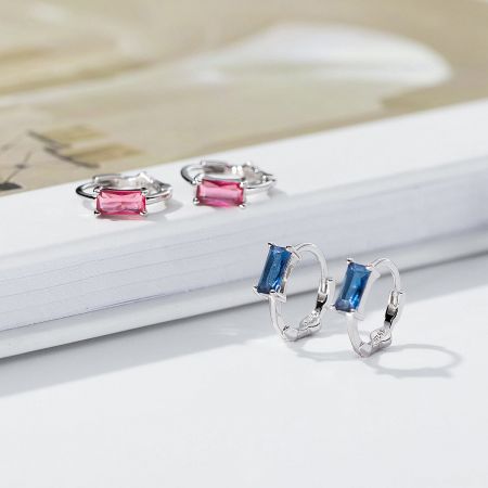 A pair of sterling silver hoop earrings with blue and pink rectangular gemstones.