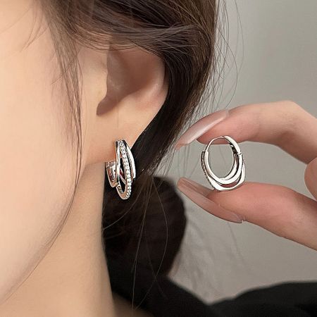 A pair of 925 sterling silver double-layered hoop earrings with inlaid CZ stones on the outer layer.