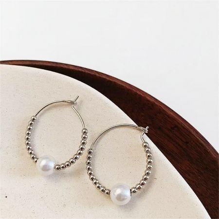 Close-up of the 925 sterling silver version of the pearl hoop earrings, showcasing the intricate beadwork.