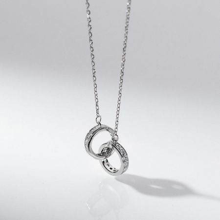 Detailed view of the silver interlocking circle pendant necklace with CZ stones.