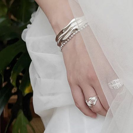 A model's hand showcasing multiple rings from the French-style shell pearl adjustable ring set.