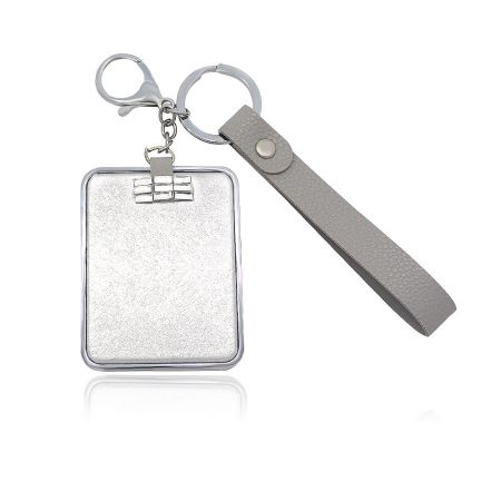 Close-up of the compact mirror's silver-plated case and durable gray leather wrist strap.