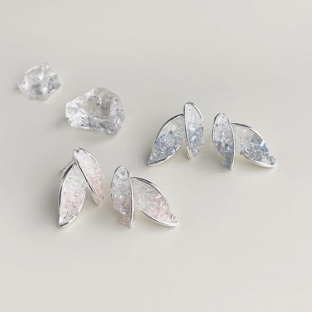 A set of silver leaf-shaped earrings with sparkling crystal components.