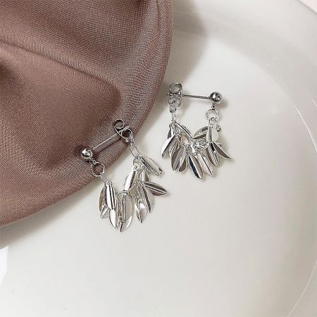 Detailed product shot of the silver leaf-inspired earrings against a white background.