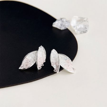 Product shot of the silver leaf earrings on a black leather-like display.