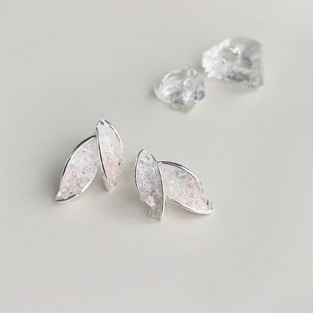 Detailed view of the silver leaf earrings showing the pale pink and clear crystal texture.