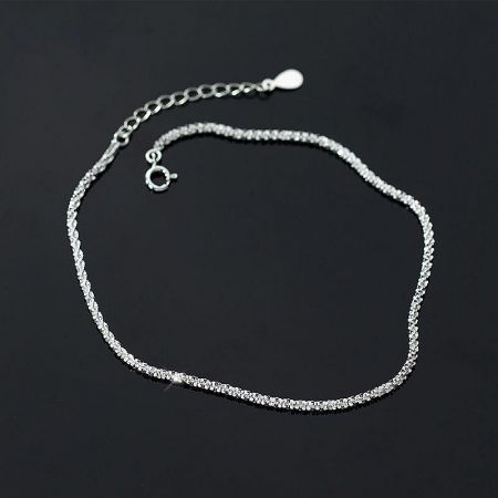 The sparkling 925 silver anklet displayed on a dark background to highlight its intricate link design.