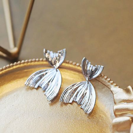 925 Sterling Silver Sea Beach Ocean Mermaid Tail Dangle Earrings (5 pairs) - A pair of 925 sterling silver mermaid tail dangle earrings elegantly displayed on a golden dish, showcasing their intricate design.