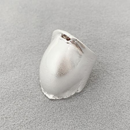 Detailed view of the polished silver finish on a drum-shaped brass ring.