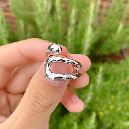 A model wearing one of the geometric curve open rings to show its adjustable fit.