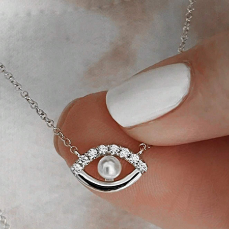 Product shot of the sterling silver evil eye necklace with a pearl and zircon stones.