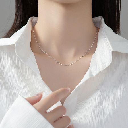 A model wearing the delicate 925 sterling silver snake chain necklace, highlighting its elegant drape.