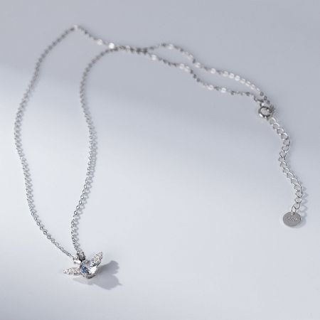 A delicate silver necklace from the collection featuring a bird-shaped pendant.