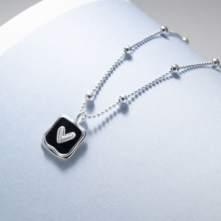 Minimalist 925 sterling silver black heart pendant necklace displayed on a neutral background.