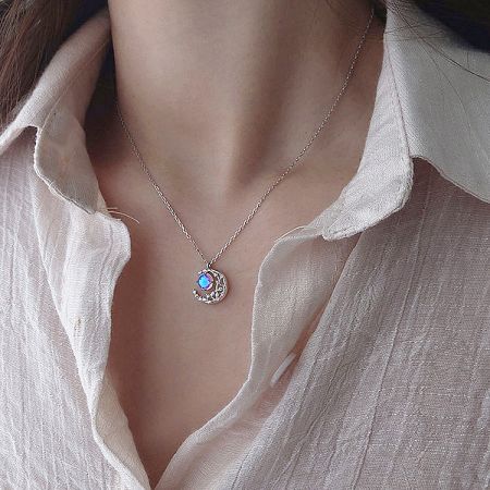 Model wearing a 925 silver necklace with a captivating blue opalescent stone pendant, part of the celestial collection.