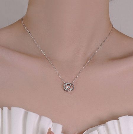 Detailed view of the double C pendant on the sterling silver necklace.