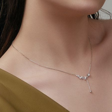 Model shot showcasing the silver leaf tassel necklace, demonstrating its length and how it complements an outfit.